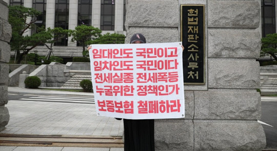 작년 8월 서울 종로구 헌법재판소 앞에서 열린 등록주택임대사업자 임대보증보험 법령 효력정지 가처분 청구 기자회견에서 대한주택임대인협회 관계자가 법령 효력정지를 촉구하는 피켓을 들고 있다. <연합뉴스>